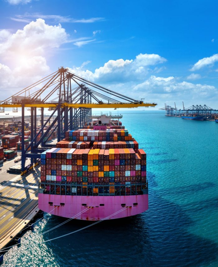Aerial view of cargo ship and cargo container in harbor.